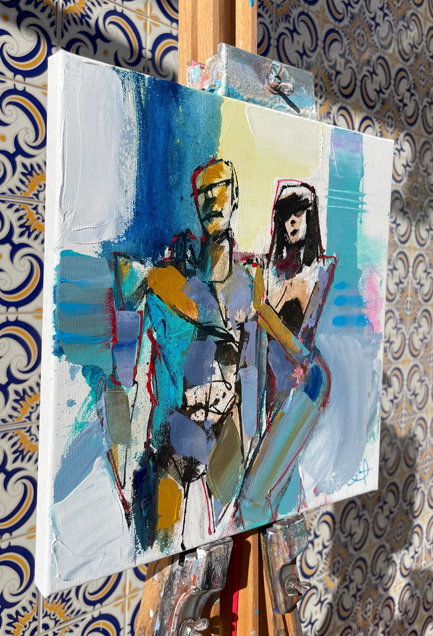 Abstract painting on an easel against a patterned wall